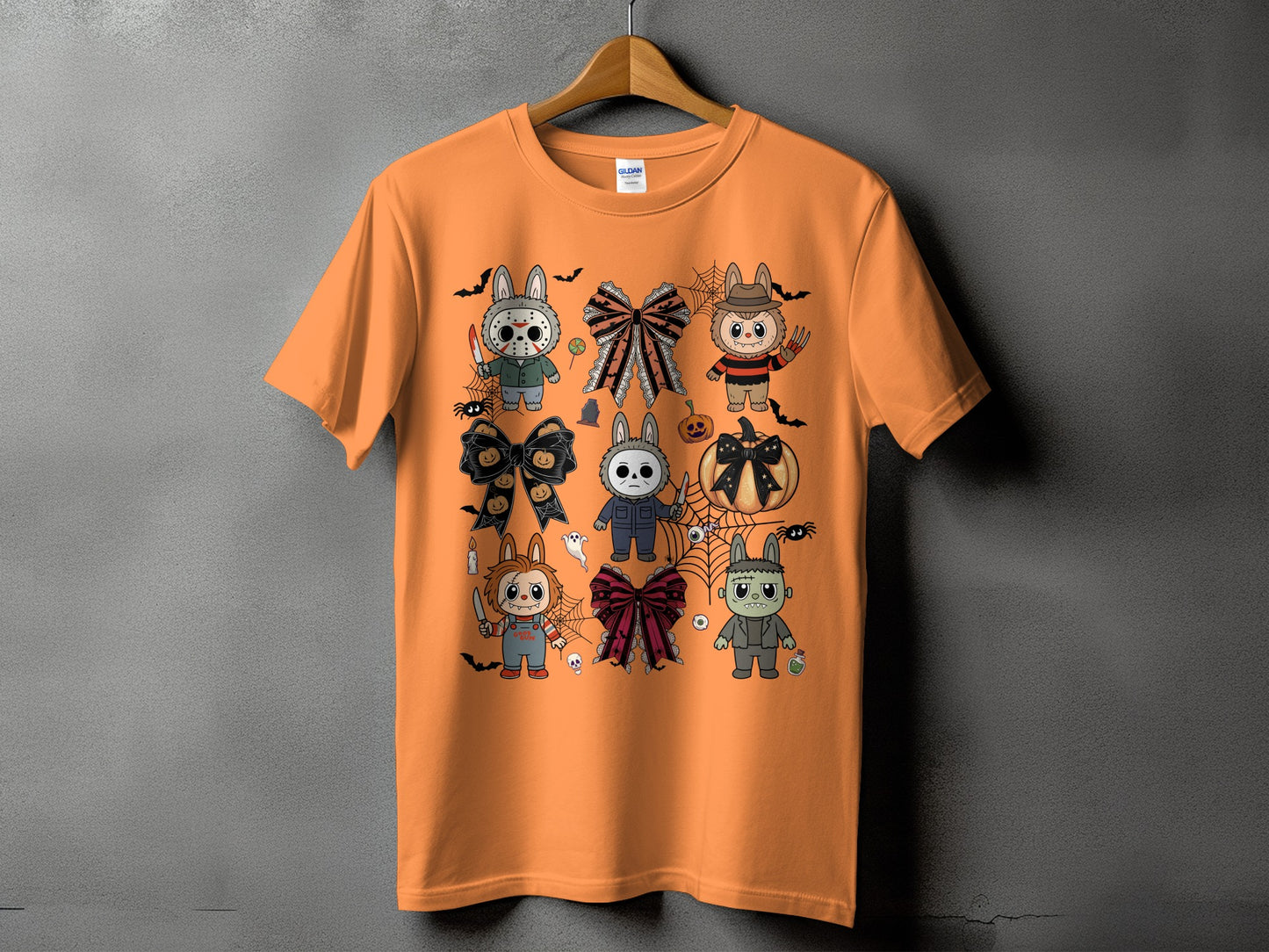 Orange t-shirt with cartoon Halloween characters, bows, and pumpkin graphic.