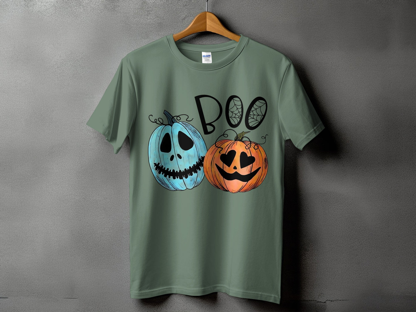 Green t-shirt with "BOO" text and two cartoon pumpkins with spiderwebs.