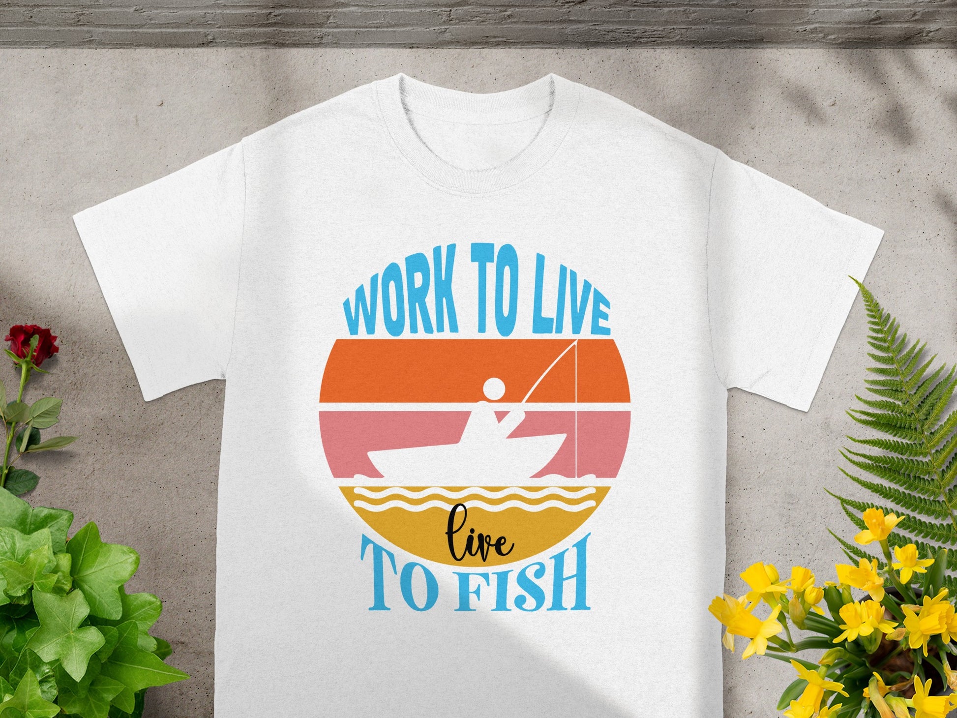 White t-shirt with graphic: "Work to Live, Live to Fish" and boat on water.