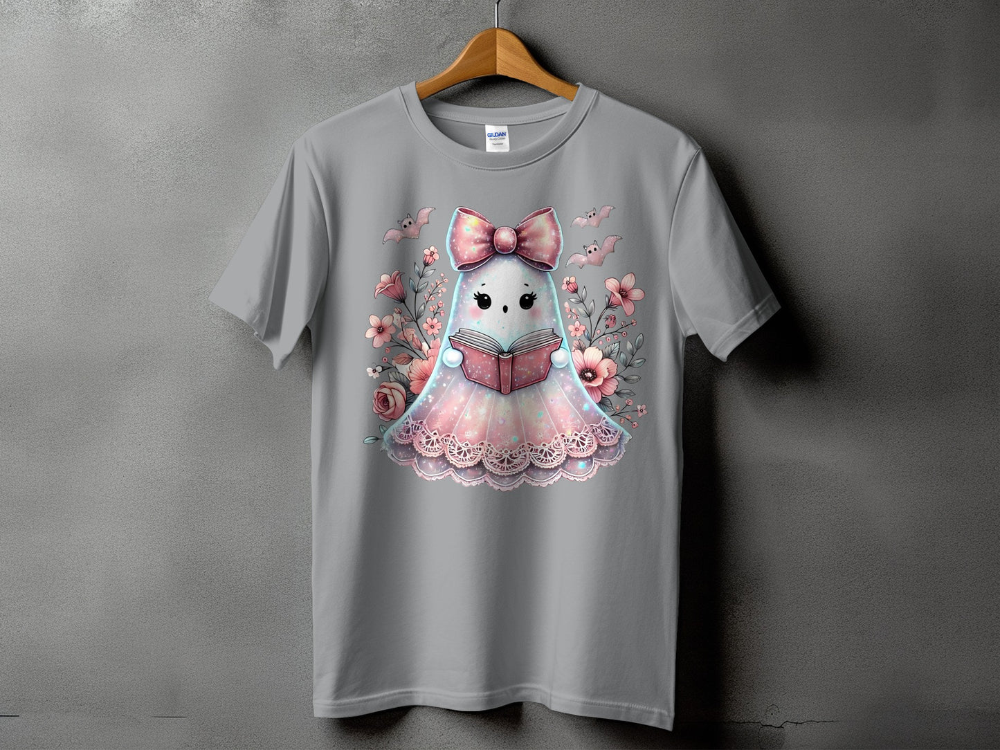 Gray t-shirt with a kawaii ghost wearing a bow reading a book surrounded by flowers.
