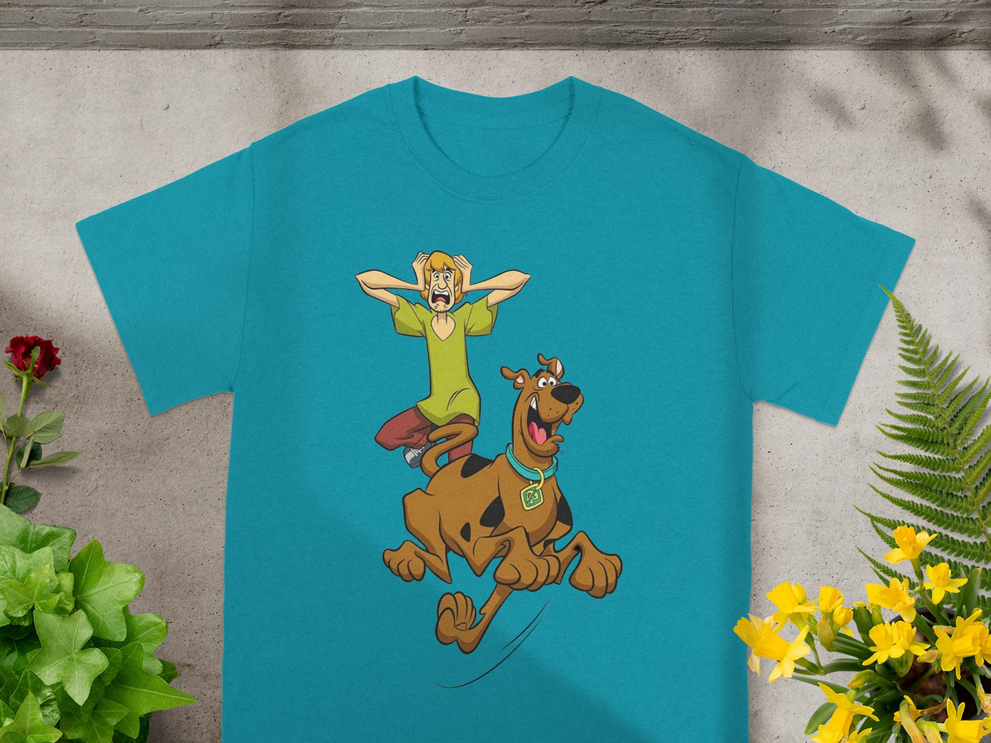 Scooby-Doo and Shaggy run terrified from a shadow on a turquoise t-shirt.