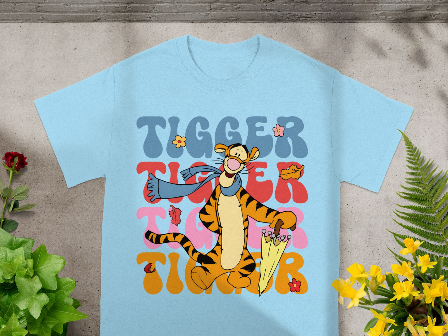 Tigger with umbrella and scarf, "Tigger" text in colorful wavy font.
