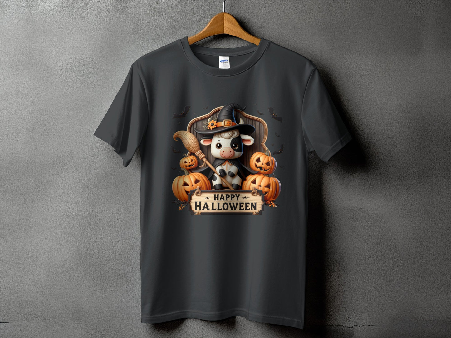 Dark t-shirt with a cartoon cow in a witch hat and bats with "Happy Halloween" text.