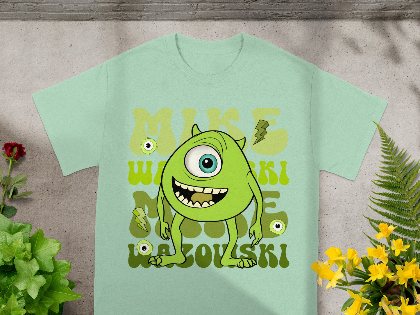 Mike Wazowski t-shirt with green cartoon character and lightning bolts.