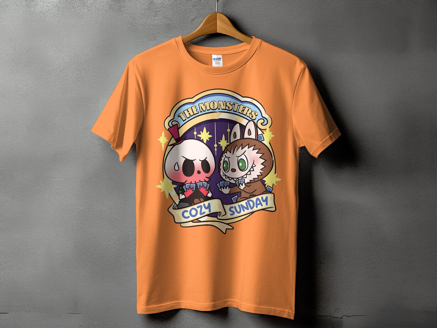 Orange t-shirt with "THE MONSTERS COZY SUNDAY" graphic featuring cartoon skull and werewolf characters.