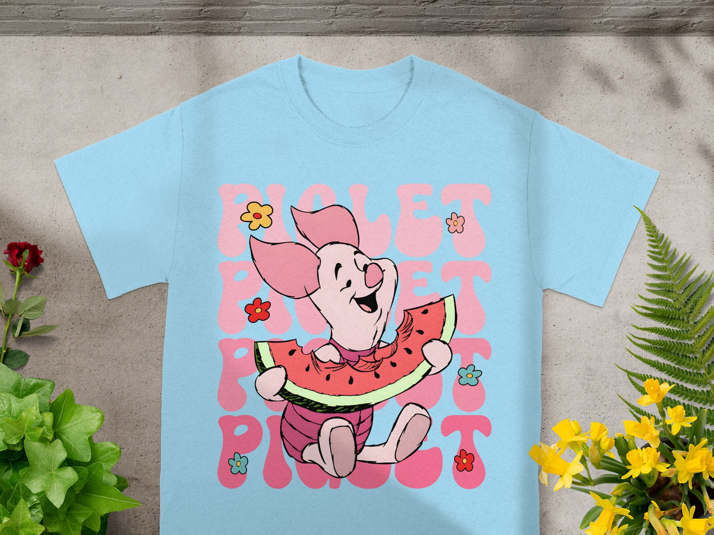 Piglet eating watermelon with "Piglet" text on a light blue t-shirt.