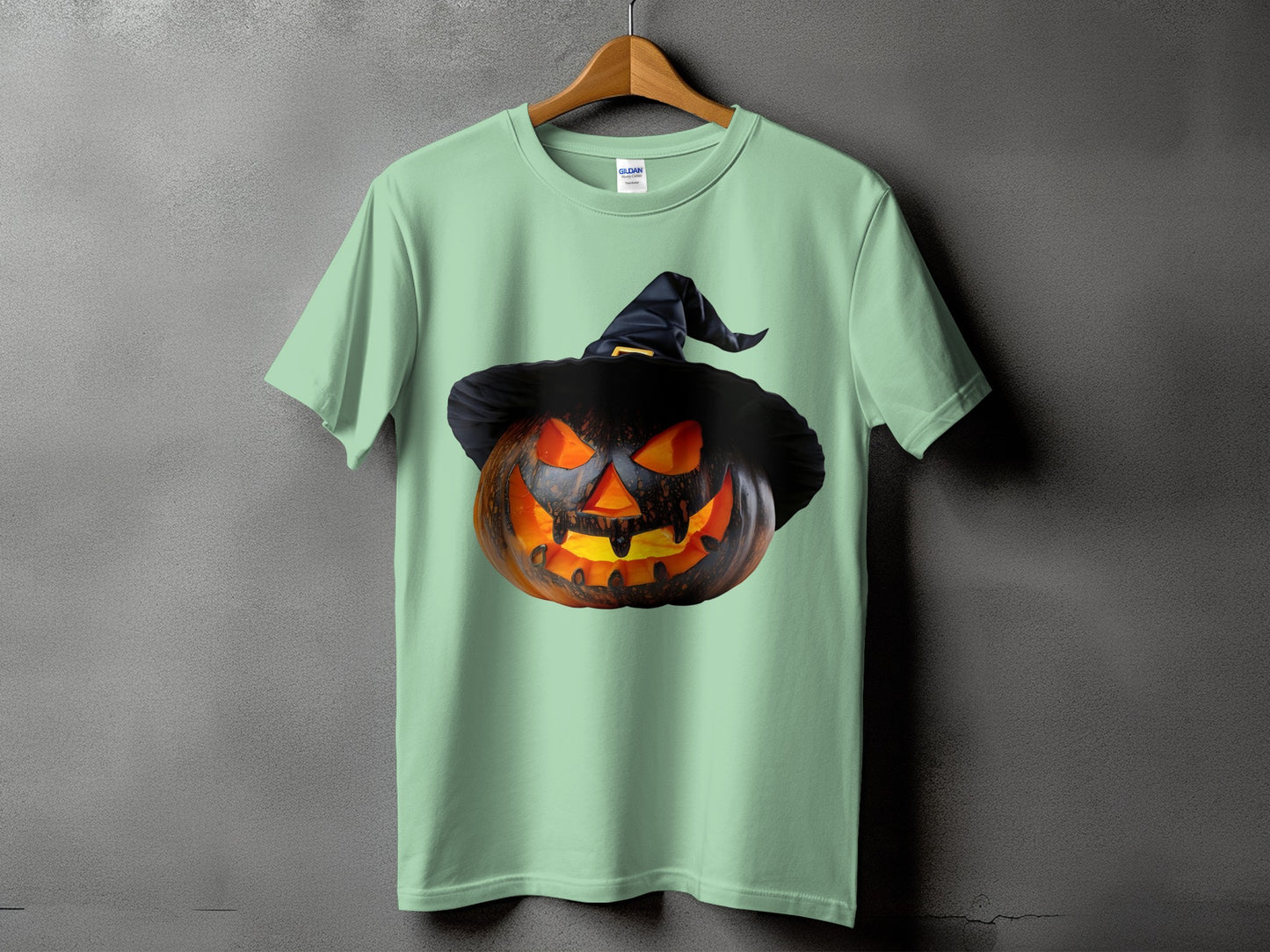 Light green t-shirt with a carved, glowing jack-o'-lantern wearing a witch hat graphic.