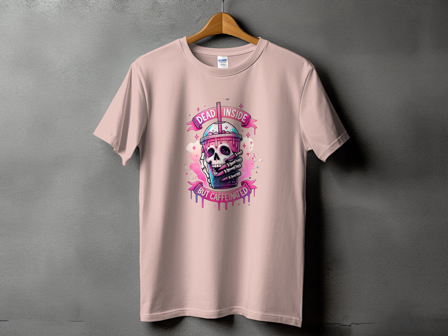 Pink t-shirt with skull holding a coffee cup and text "Dead Inside But Caffeinated".