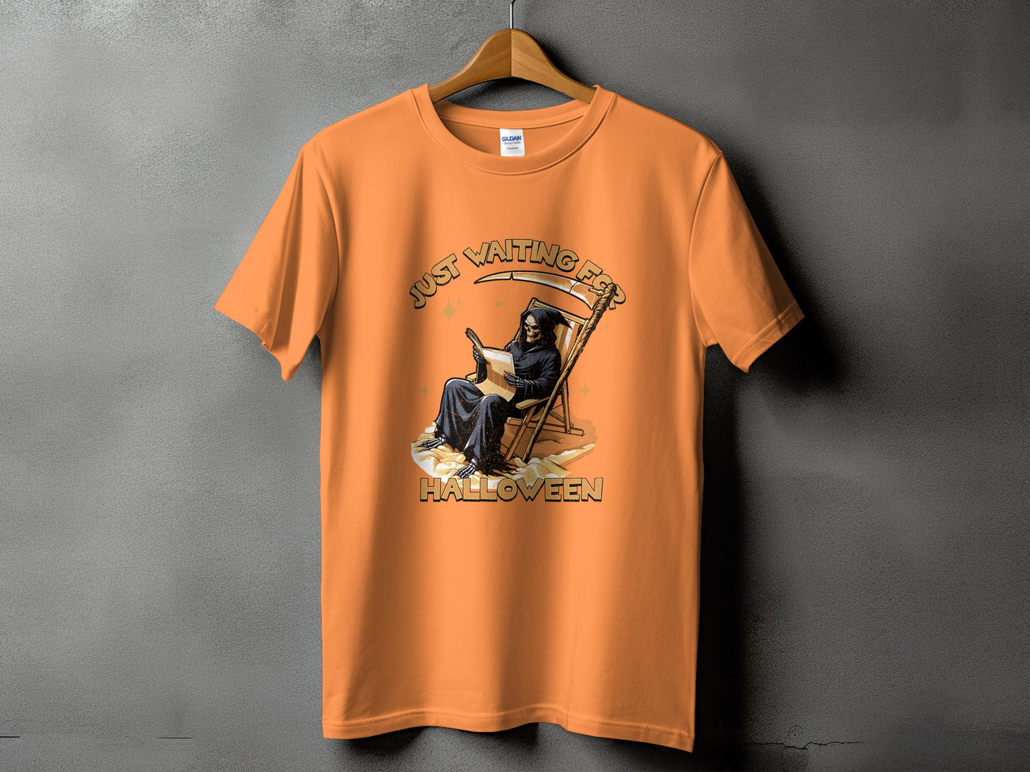 Orange t-shirt with Grim Reaper reading a newspaper, "Just Waiting For Halloween" text.