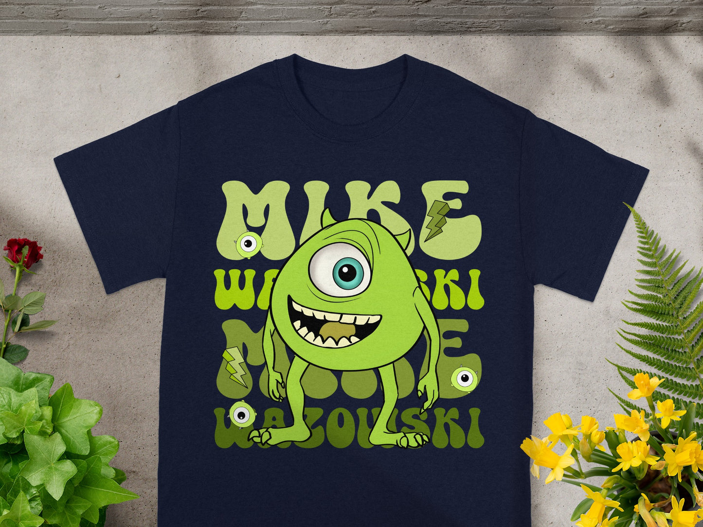 Navy t-shirt with green cartoon monster "MIKE" Wazowski graphic and yellow lightning bolts.