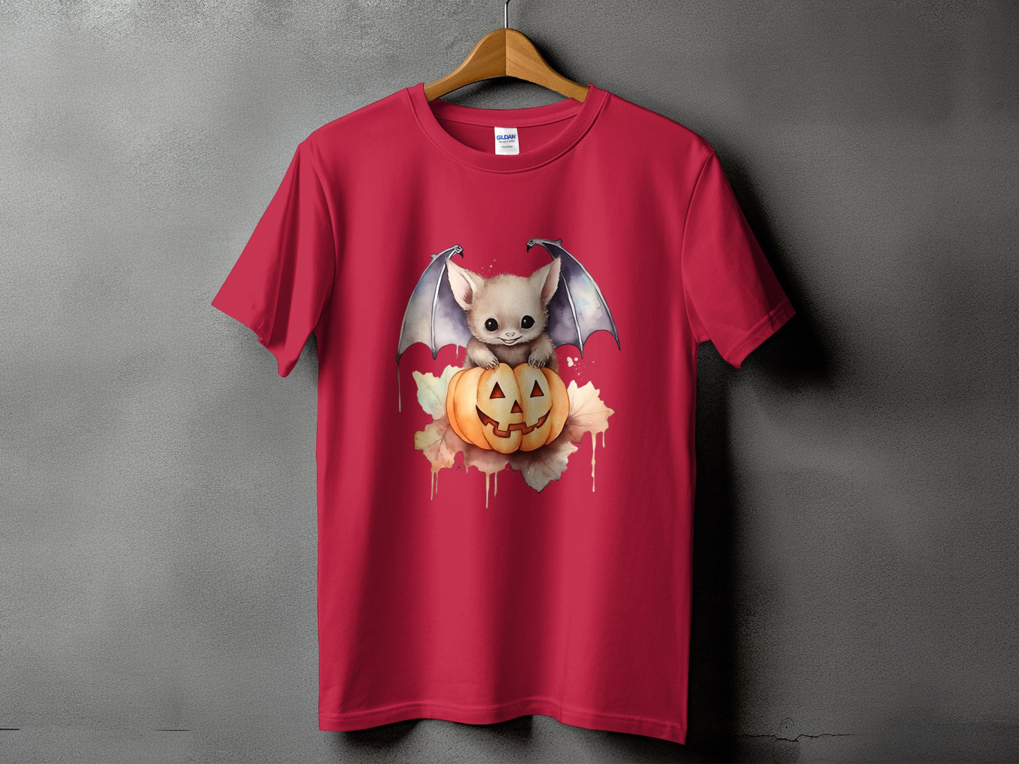 Red t-shirt with a cute bat sitting on a jack-o'-lantern with autumn leaves.