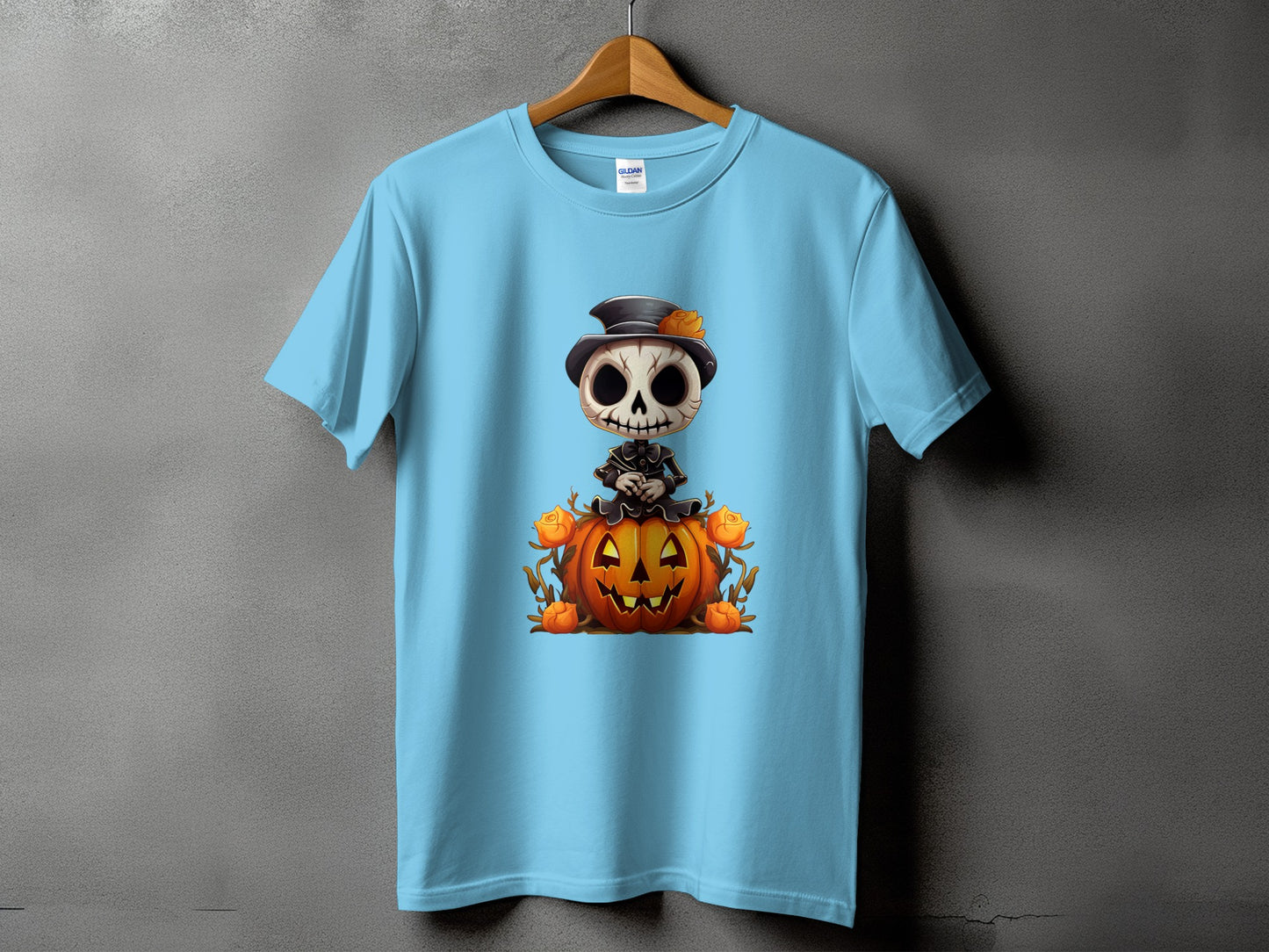 Light blue t-shirt with cartoon skeleton sitting on a Halloween pumpkin.