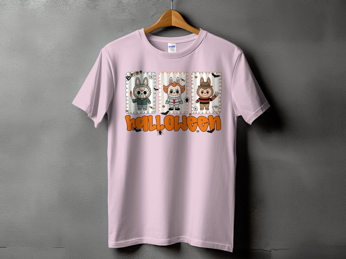 Pink t-shirt with cartoon Halloween characters and the word "halloween" in orange.