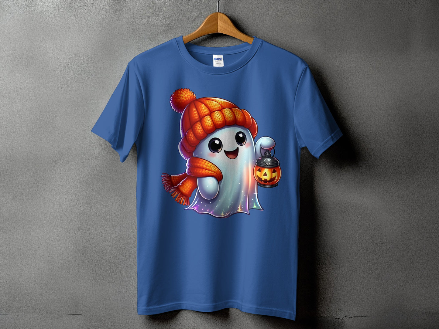 Blue t-shirt featuring a cute ghost wearing a knitted hat and scarf, holding a jack-o'-lantern.
