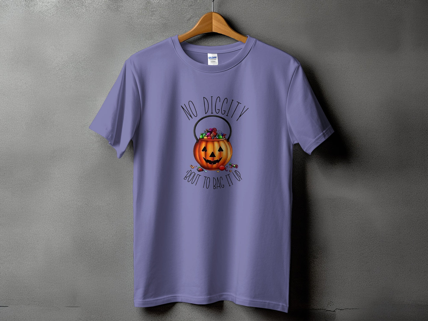 Purple t-shirt with Halloween graphic of a jack-o'-lantern candy pail and text.