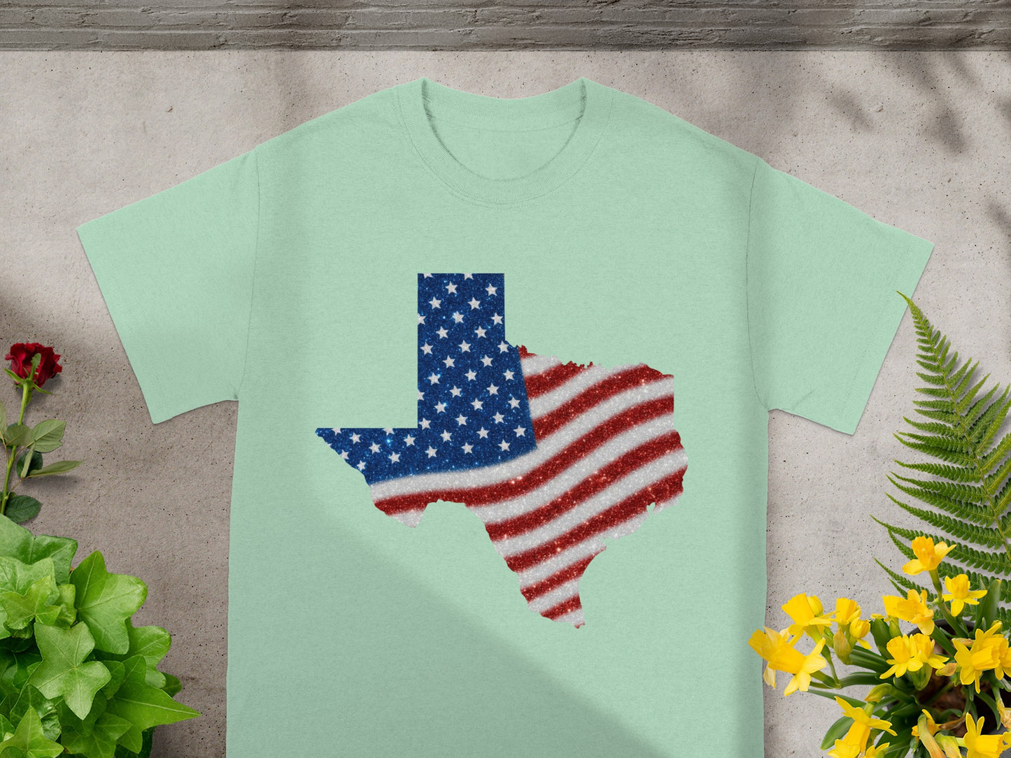 Light green t-shirt with Texas outline filled with American flag glitter design.