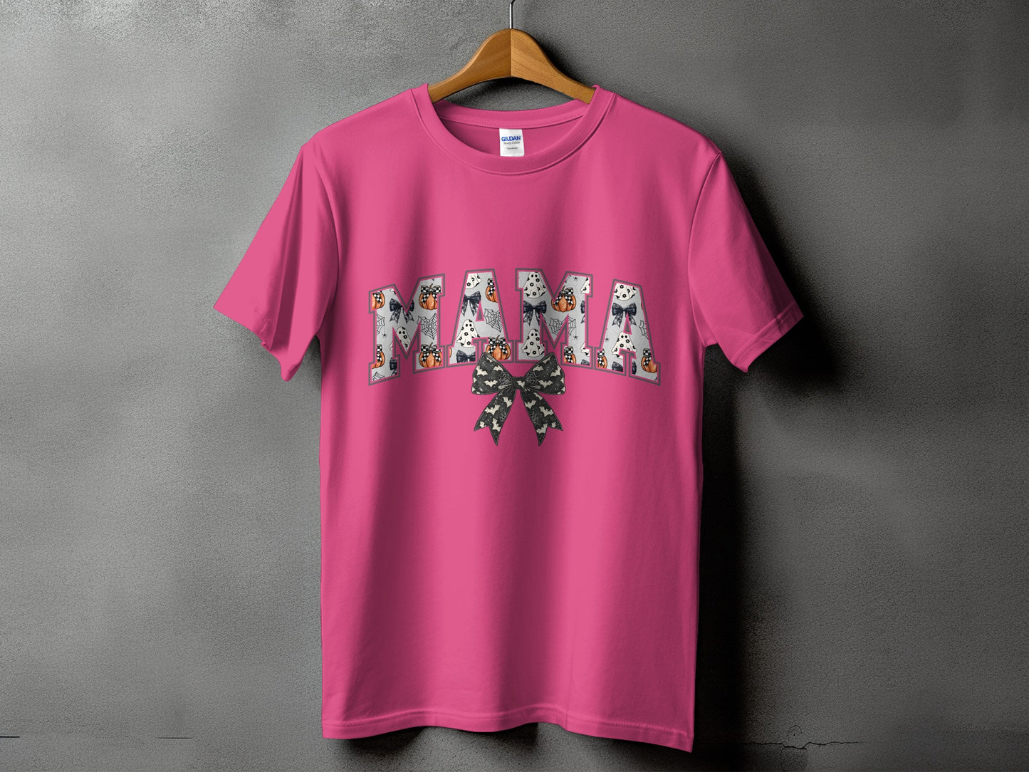 Pink t-shirt with "MAMA" text filled with Halloween motifs and a bow.