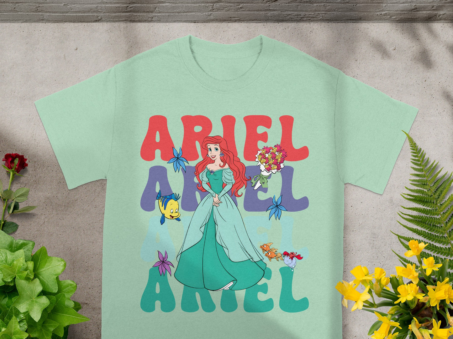 Ariel from The Little Mermaid on a light green t-shirt.