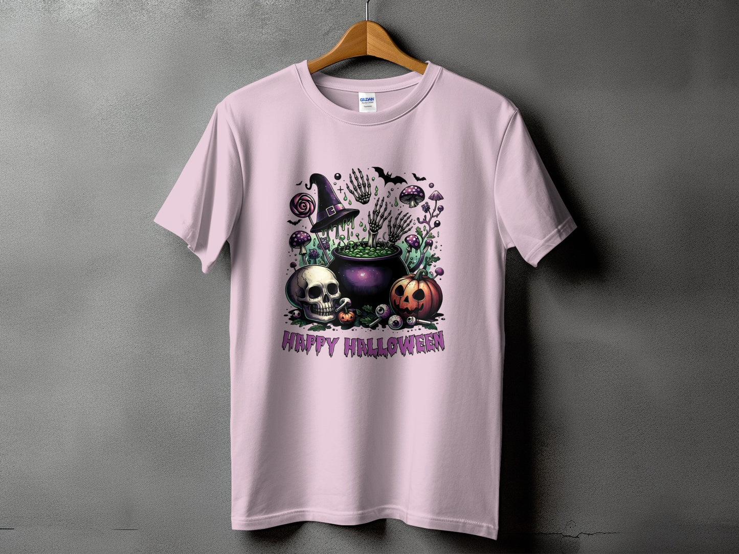 Pink t-shirt with Halloween design featuring skull, pumpkin, cauldron, and "Happy Halloween" text.