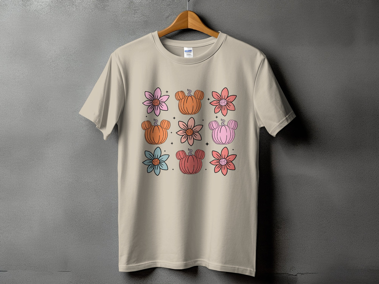 Light tan t-shirt with a repeating pattern of pastel-colored flowers and Mickey-shaped pumpkins.