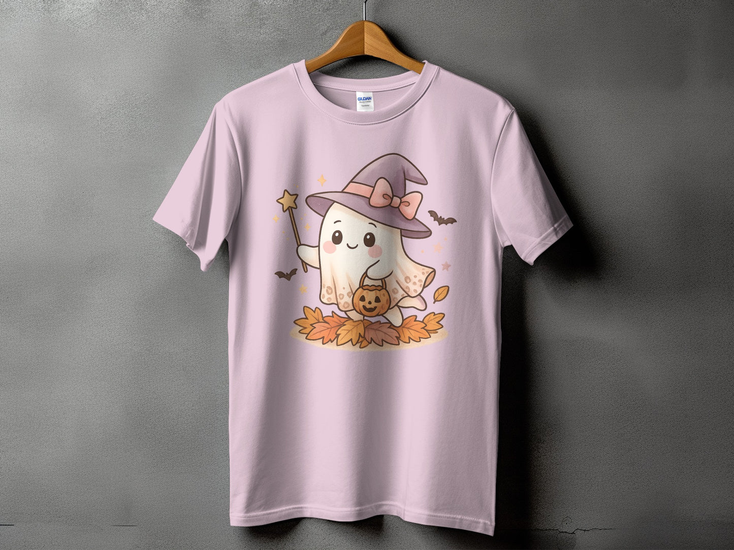 Pink t-shirt with a ghost wearing a witch hat, holding a pumpkin and wand.