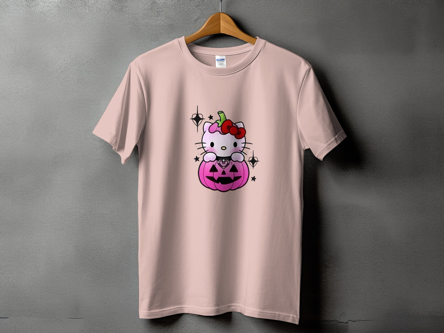 Pink t-shirt with Hello Kitty sitting inside a carved pumpkin with stars.