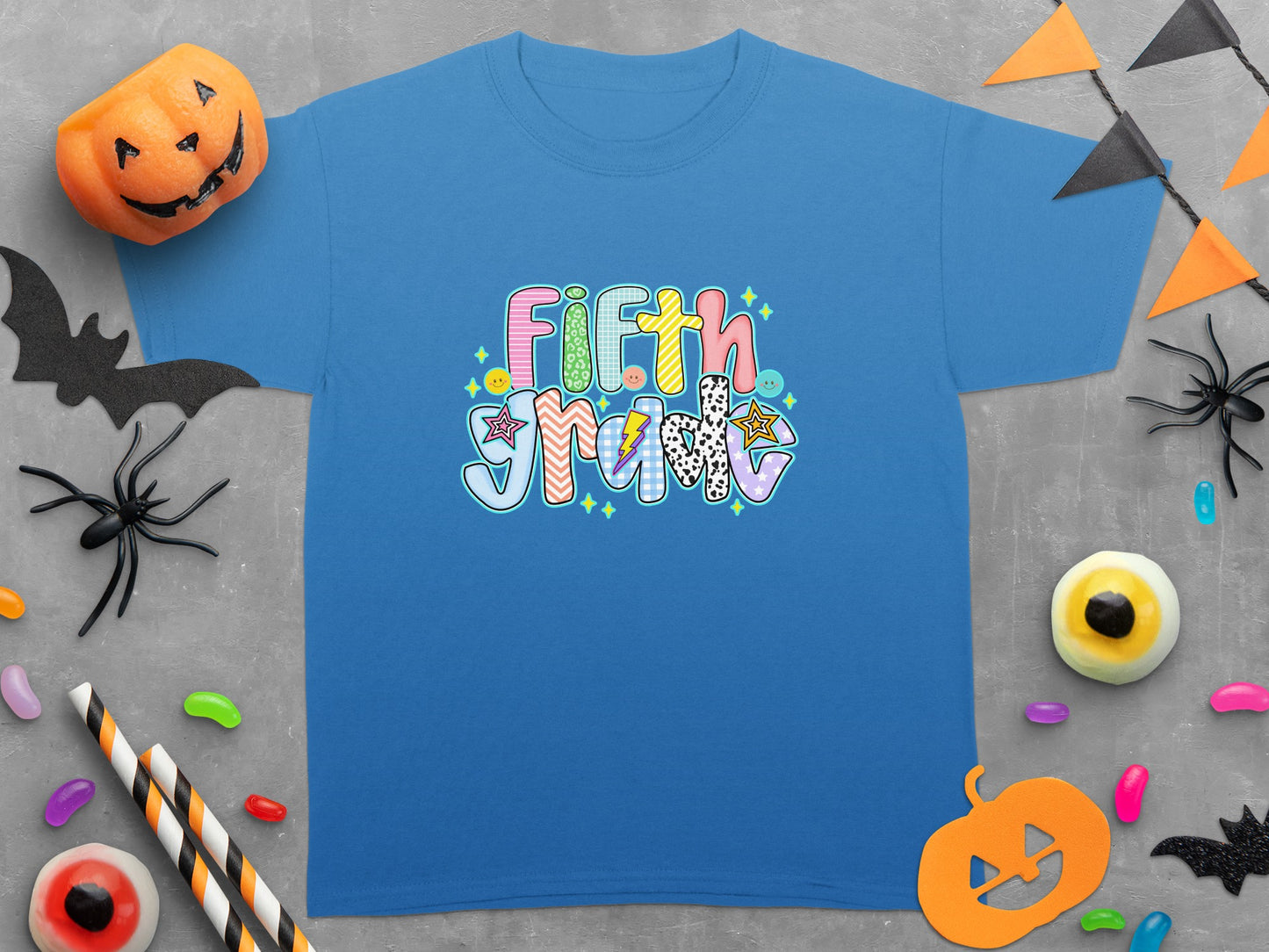 Blue t-shirt with colorful "Fifth Grade" text and Halloween decorations.
