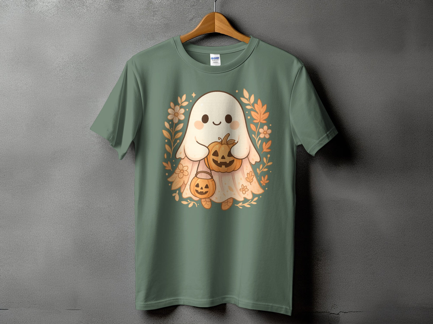 Green t-shirt with a cute cartoon ghost holding pumpkins and surrounded by autumn leaves.