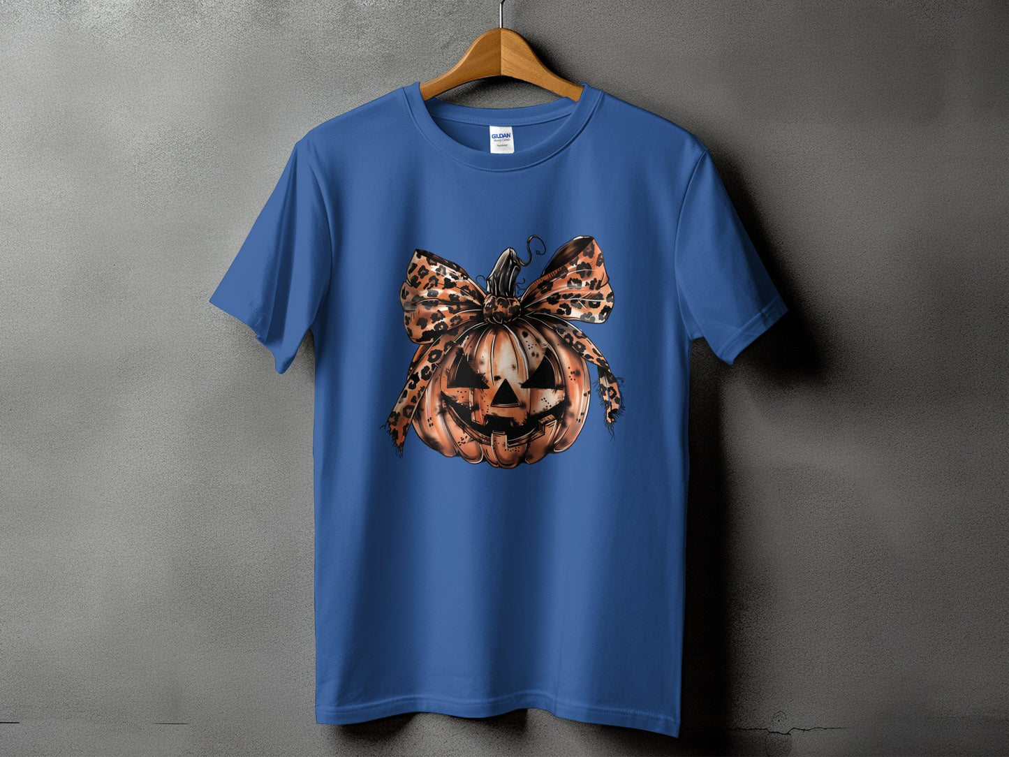Blue t-shirt with a jack-o'-lantern graphic featuring a leopard print bow.
