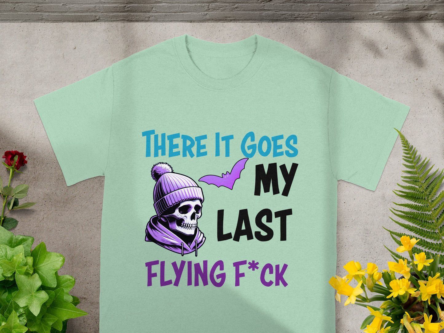 Mint green t-shirt with skull, bat, and text: "THERE IT GOES MY LAST FLYING F*CK".