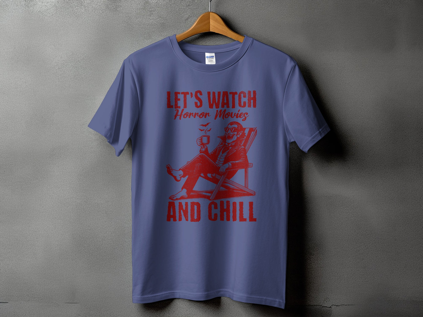 Purple t-shirt with red graphic of a vampire in a deck chair saying "Let's Watch Horror Movies And Chill".