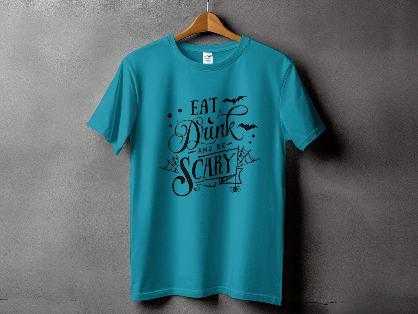 Teal t-shirt with black Halloween text "Eat, Drink, and Be Scary" and graphics.
