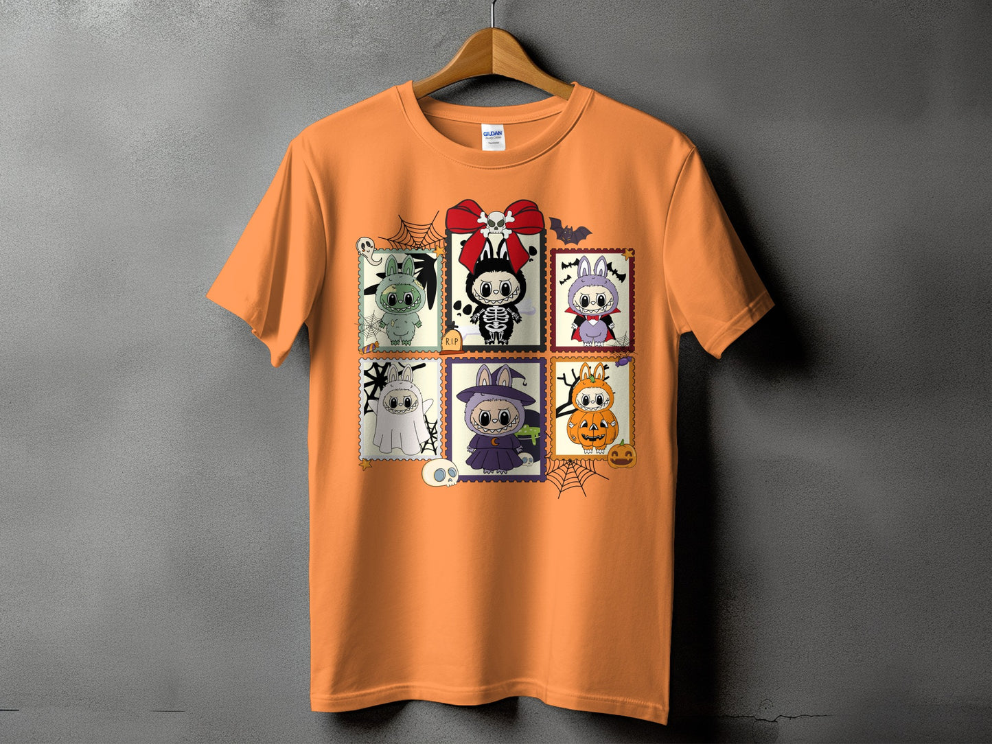 Orange t-shirt with six Halloween-themed stamp-like illustrations of cute characters.