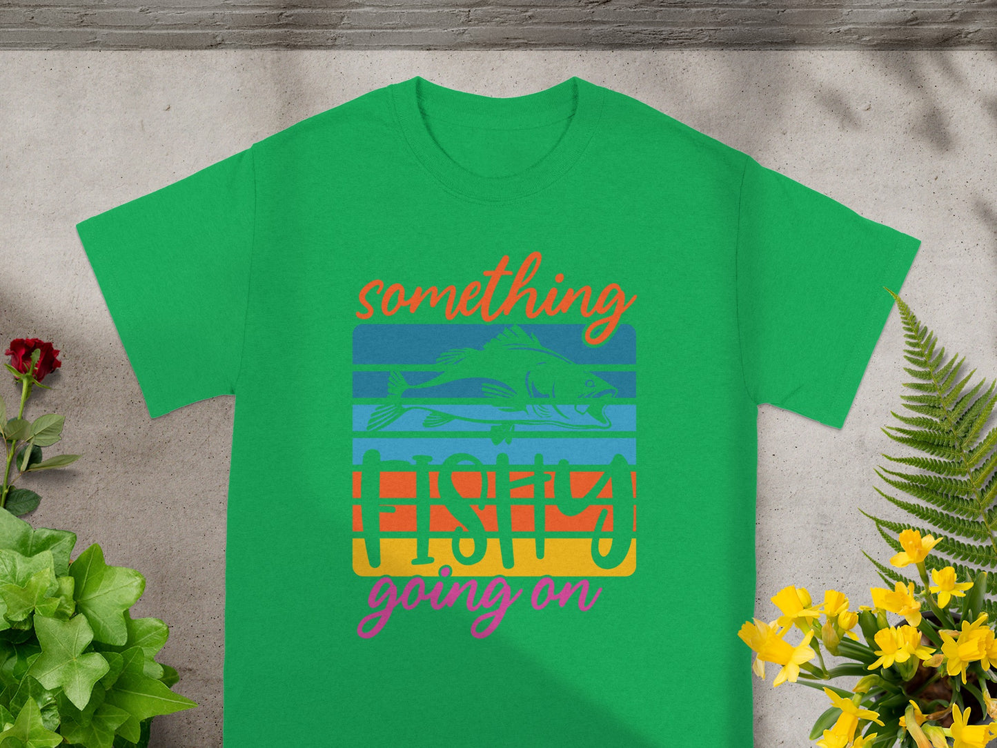 Green t-shirt with "Something fishy going on" text and fish graphic.