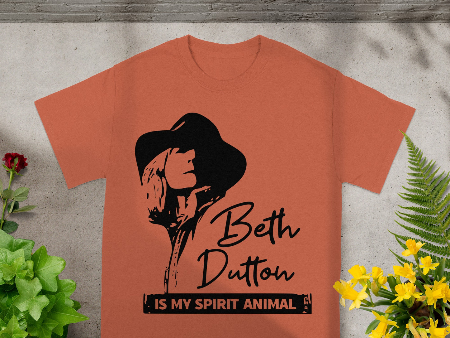 Orange t-shirt with black Beth Dutton graphic and text.