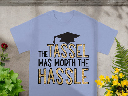 Light blue t-shirt with black graduation cap and gold glitter text.