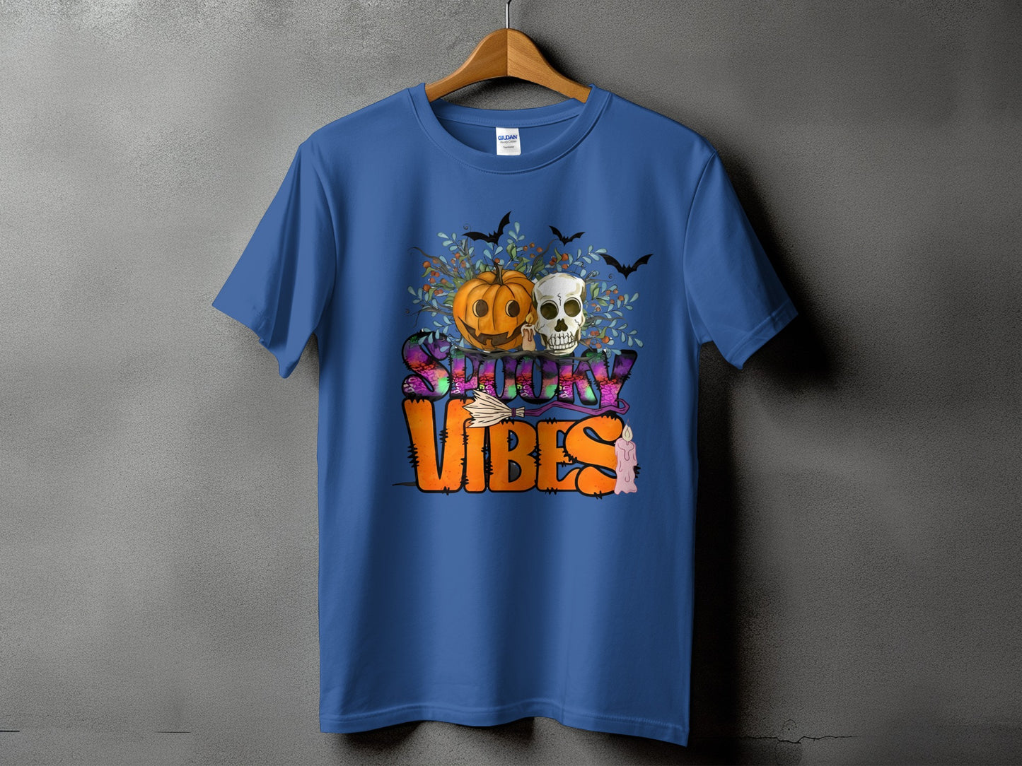 Blue t-shirt with Halloween graphic featuring pumpkin, skull, bats, and "Spooky Vibes" text.