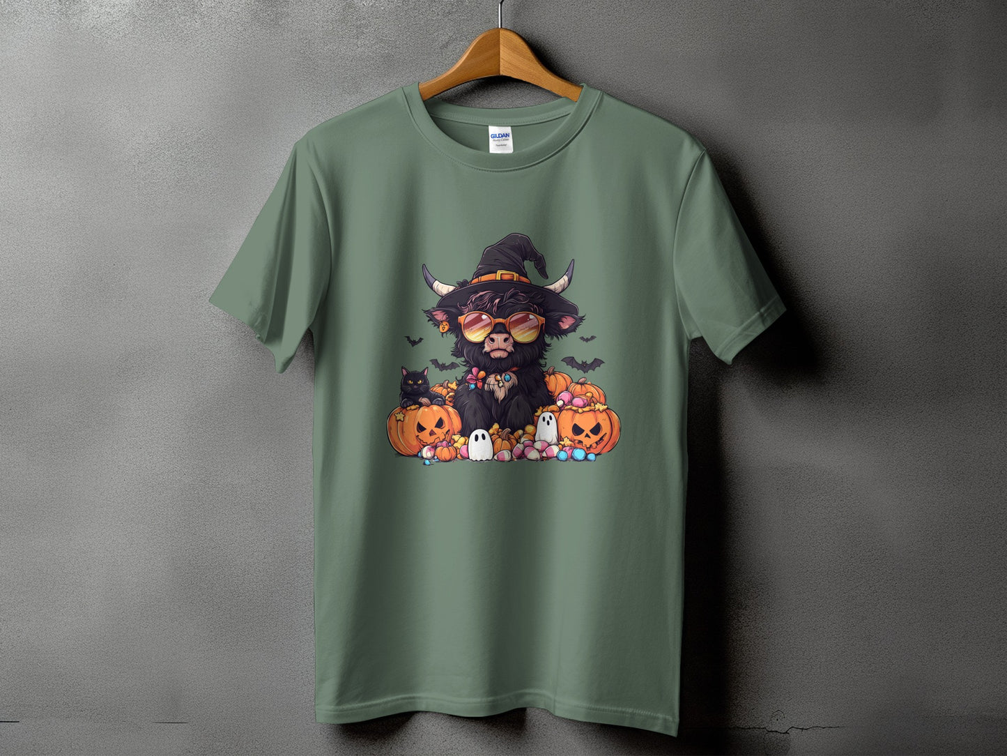 Highland cow in witch hat with pumpkins and ghosts on a t-shirt.