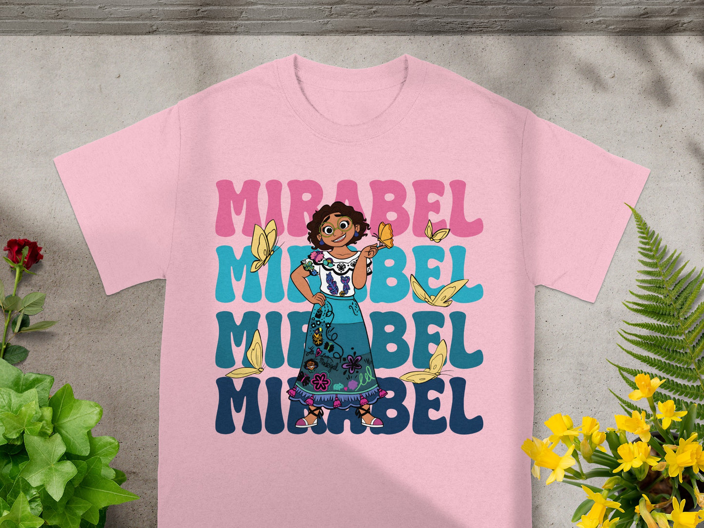 Mirabel from Encanto on a pink t-shirt with butterflies and repeating text.
