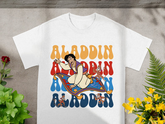 Aladdin, Abu, and magic carpet graphic with "Aladdin" text on a white t-shirt.