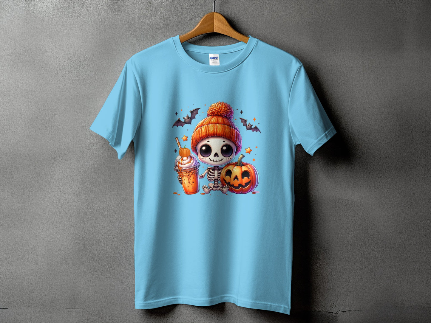 Light blue t-shirt with cartoon skeleton, pumpkin, and Halloween bats graphic.
