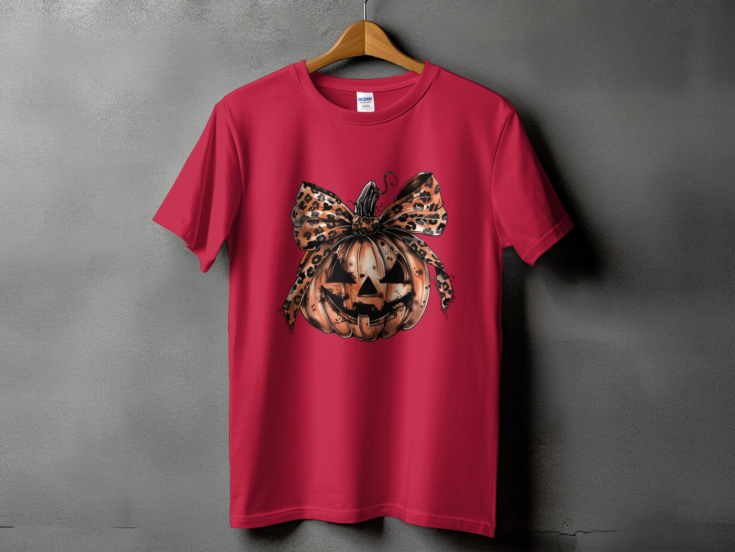 Red t-shirt with jack-o'-lantern graphic featuring a leopard print bow.