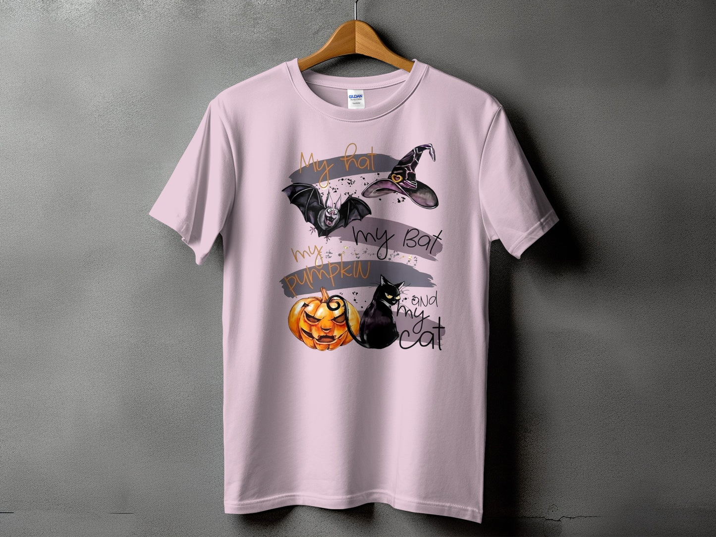 Pink t-shirt with Halloween graphic of a bat, witch hat, jack-o'-lantern, and black cat.