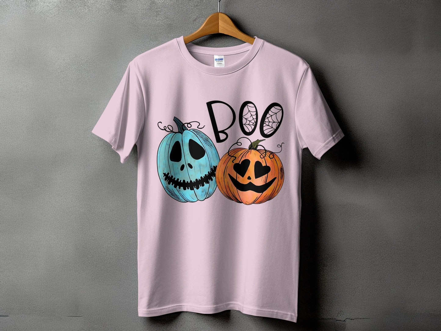 Pink t-shirt with "BOO" text and two cartoon pumpkins, one blue, one orange.