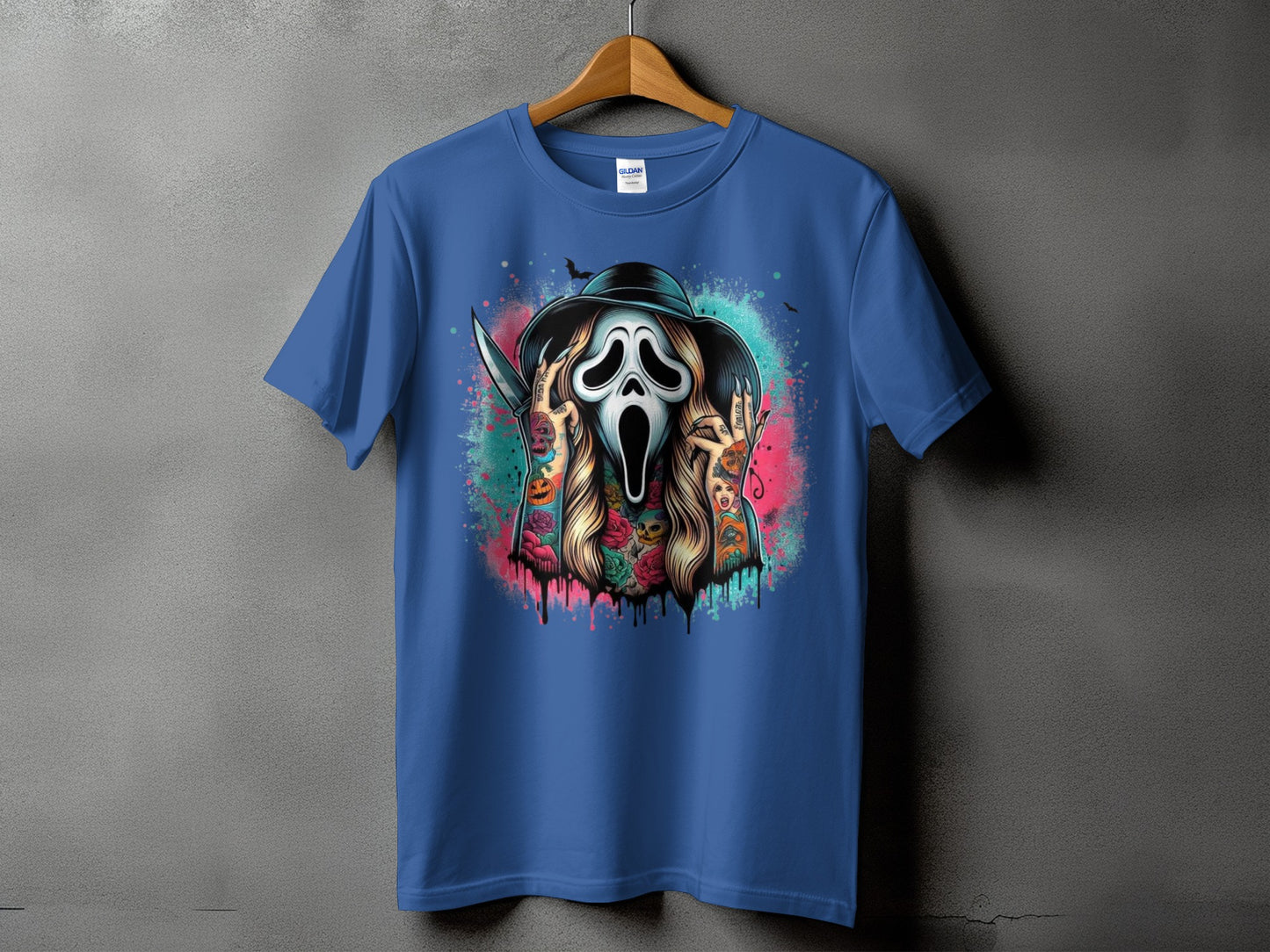 Blue t-shirt with a graphic of a ghost face with tattoos and a knife.