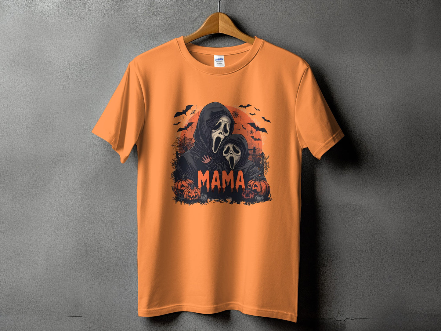 Orange t-shirt with a Halloween graphic of two masked figures and the word "MAMA".