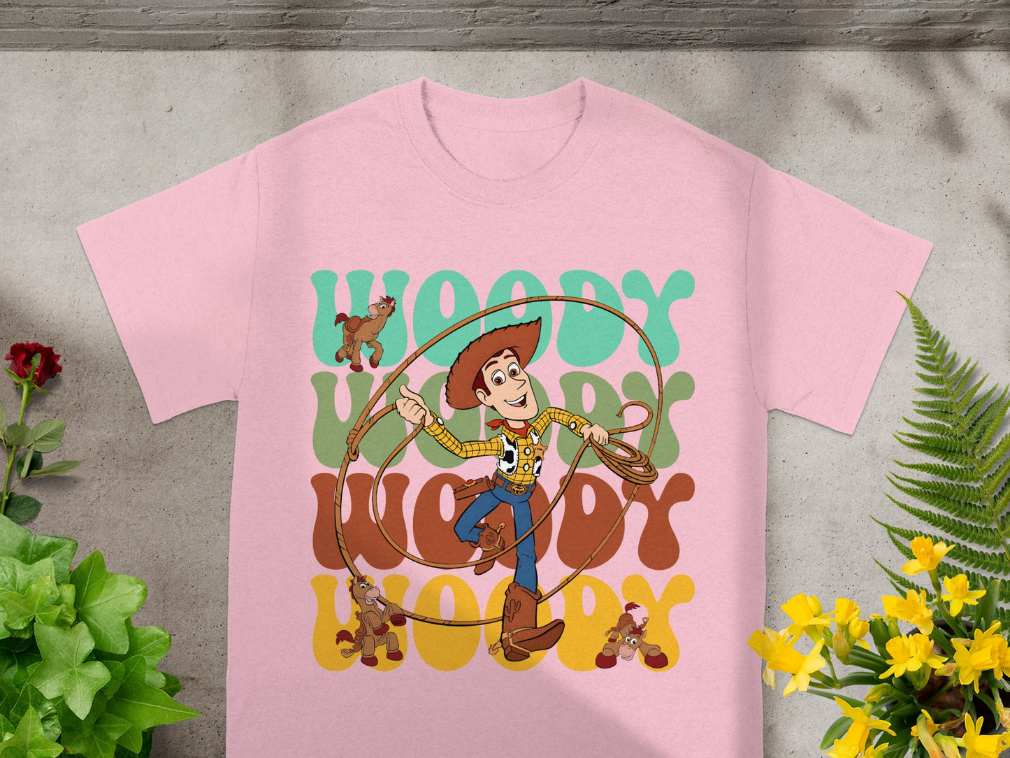 Woody from Toy Story with "WOODY" text on a pink t-shirt.