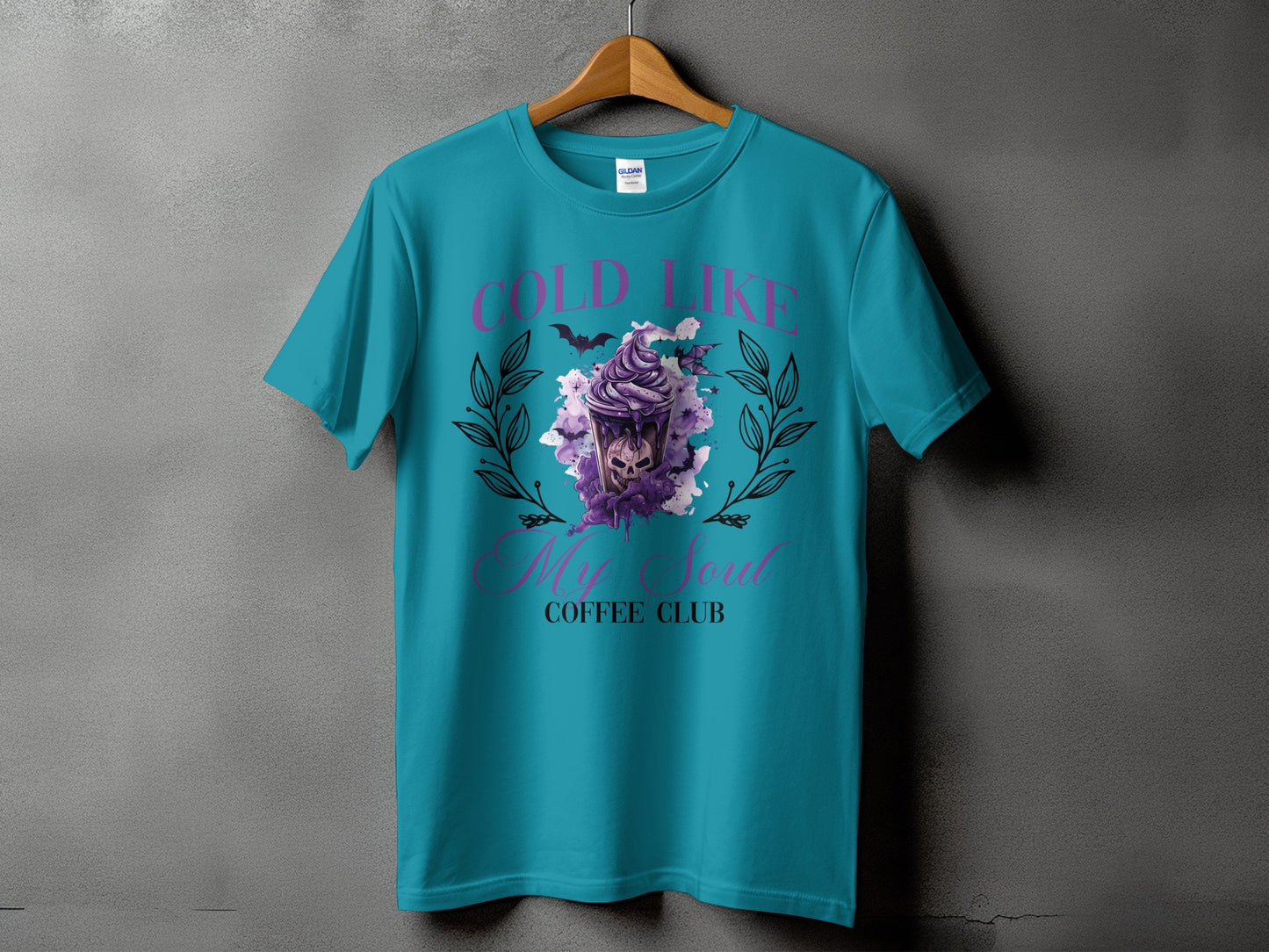 Teal t-shirt with "Cold Like My Soul Coffee Club" graphic featuring a skull and purple drink.