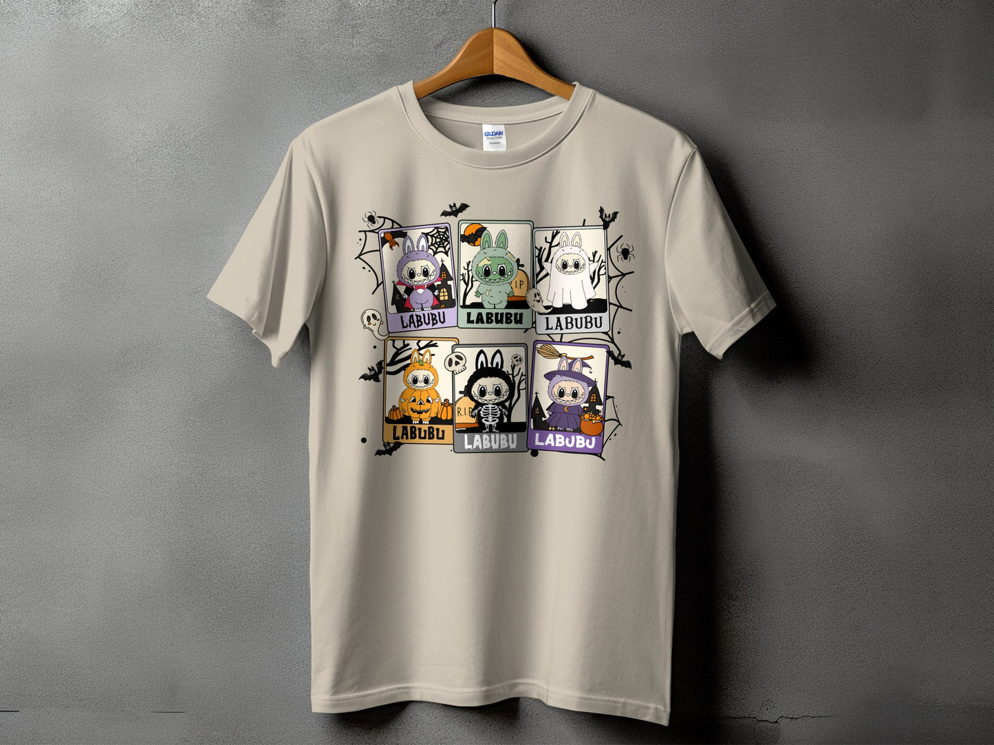 Light beige t-shirt with six Halloween-themed Labubu character panels and spiderweb graphics.