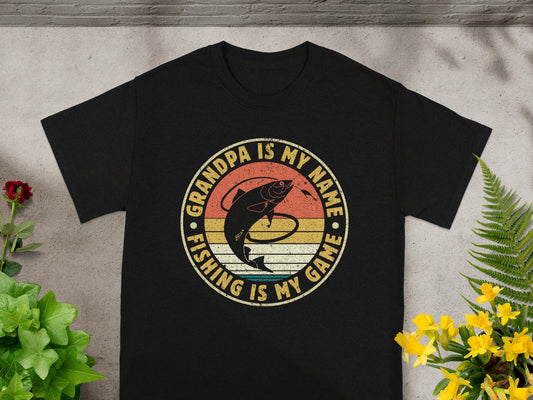 Black t-shirt with "Grandpa is my name. Fishing is my game." text and fish graphic.